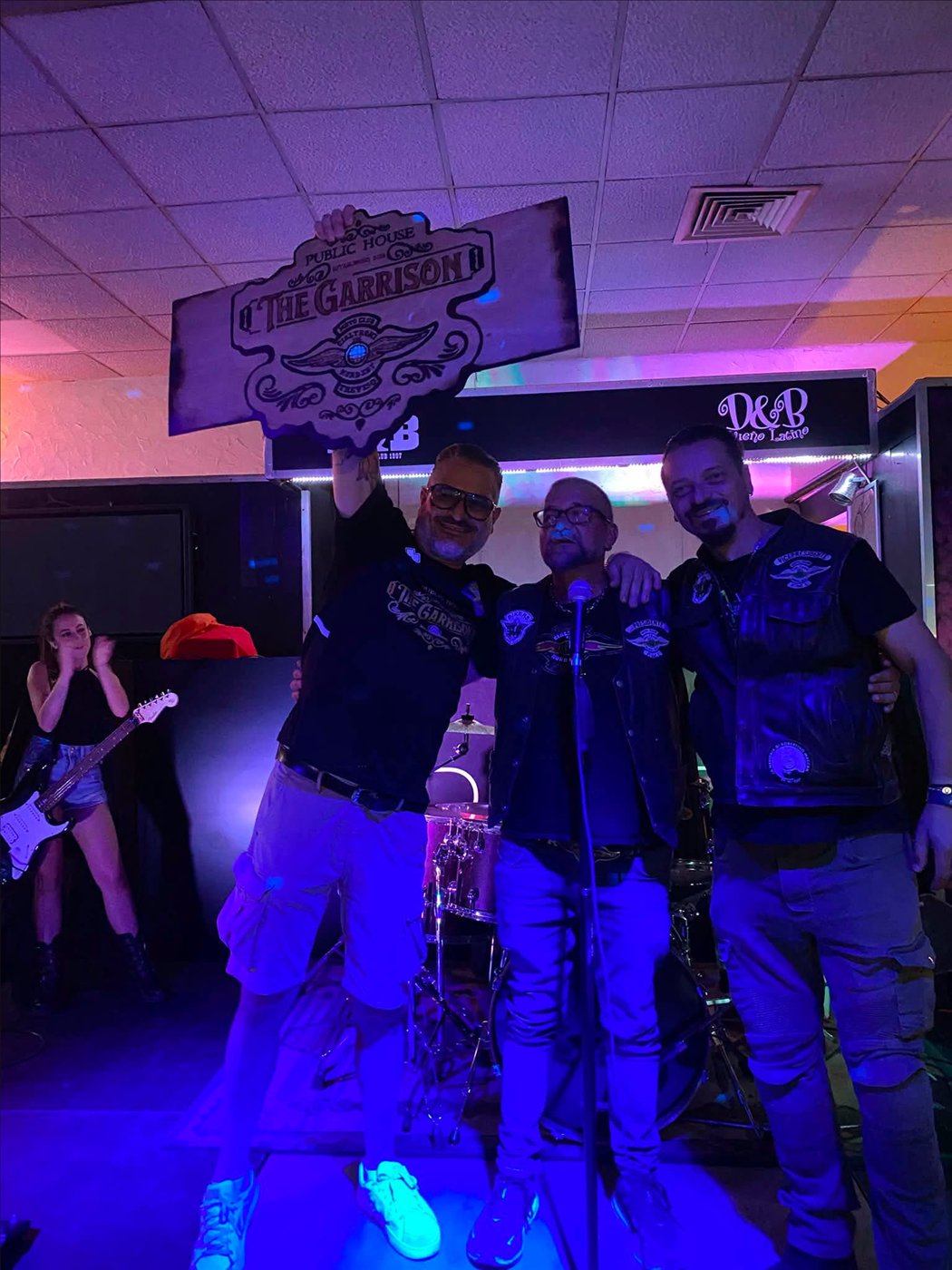 Tre amici sul palco con l’insegna del The Garrison